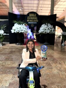 Presidente da ADEFAL, Graça Dias, recebe o Prêmio Gerônimo Ciqueira durante o Baile da Inclusão